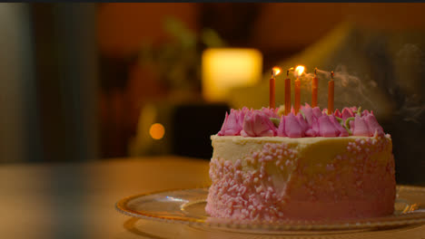 Candles-Being-Blown-Out-On-Party-Celebration-Cake-For-Birthday-Decorated-With-Icing-On-Table-At-Home-2